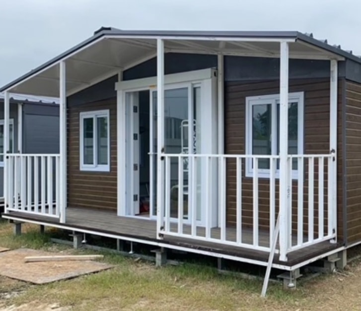 20ft brown cladded house with white frame and balcony